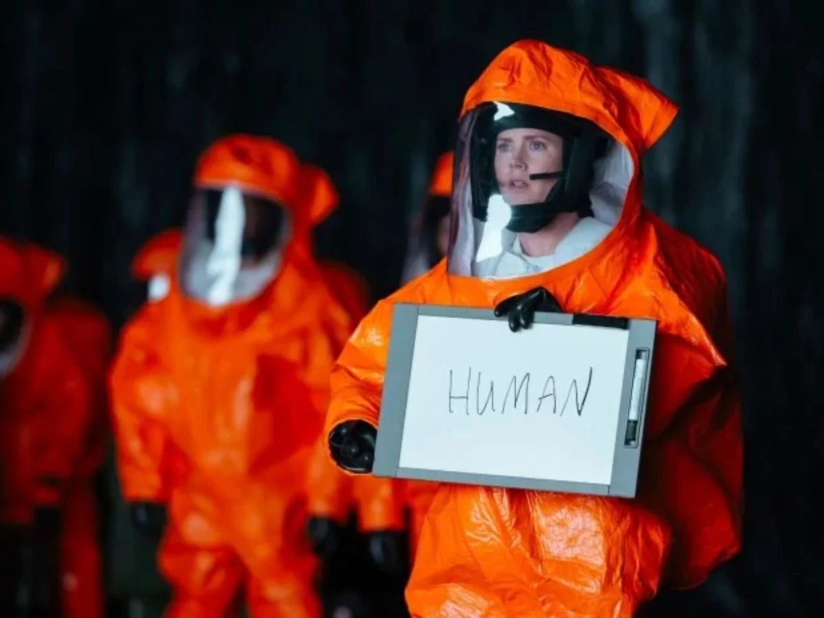 Em um ato de vulnerabilidade radical e coragem intelectual, Louise Banks utiliza o quadro branco para estabelecer o primeiro ponto de contato real, definindo a identidade de nossa espécie antes que as armas o fizessem.