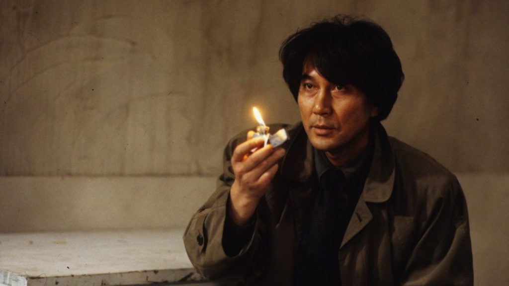 Final Explicado de Cure (1997): O Vazio que Contagia e a Anatomia do Mal Isqueiro de Mamiya simbolizando hipnose em Cure.